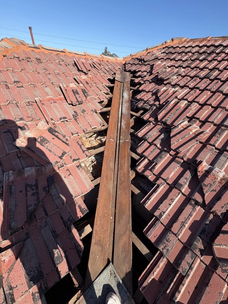 Damaged roof valley and broken tiles found during a leak repair